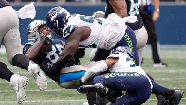 Seattle Seahawks defensive tackle Jarran Reed (90) assists cornerback Artie Burns (23) on a tackle of Carolina Panthers wide receiver Terrace Marshall Jr. (88) during the fourth quarter at Lumen Field.